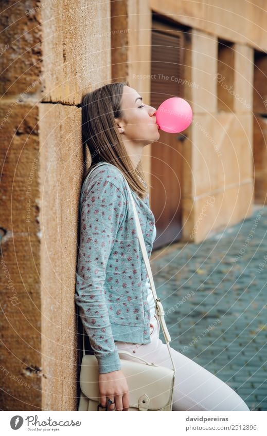 Young teenage girl blowing pink bubble gum Lifestyle Joy Happy Beautiful Face Calm Human being Woman Adults Youth (Young adults) Mouth Lips Fashion Brunette