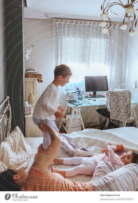 Boy jumping over the bed with his family Lifestyle Joy Happy Beautiful Relaxation Leisure and hobbies Playing Bedroom Child Baby Boy (child) Woman Adults