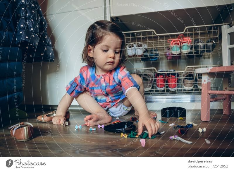 Baby girl playing with hair clips sitting in the floor Lifestyle Joy Beautiful Playing House (Residential Structure) Child Human being Woman Adults Infancy Hand