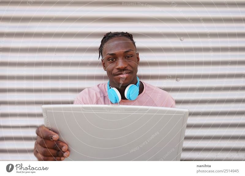 Young black man using his laptop Lifestyle Style Design Student Headset Computer Headphones Notebook Technology Entertainment electronics Internet Human being