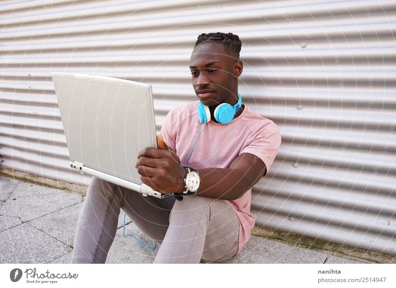 Young black man using his laptop Lifestyle Style Student Work and employment Headset Computer Notebook Headphones Technology Entertainment electronics