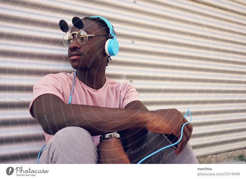 young black man listening music with his phone Lifestyle Style Design Leisure and hobbies Cellphone Headset Headphones Technology Entertainment electronics