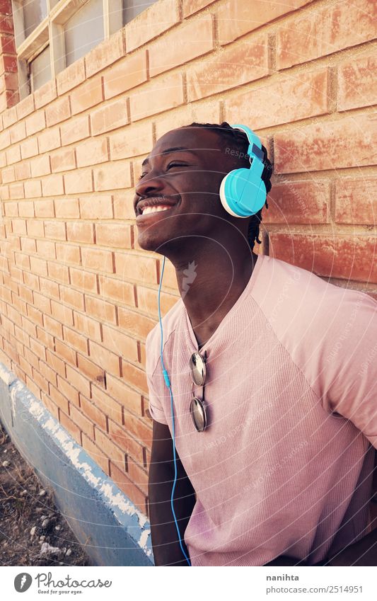 Young happy black man is listening to music Lifestyle Style Joy Wellness Well-being Contentment Headset Headphones Technology Entertainment electronics