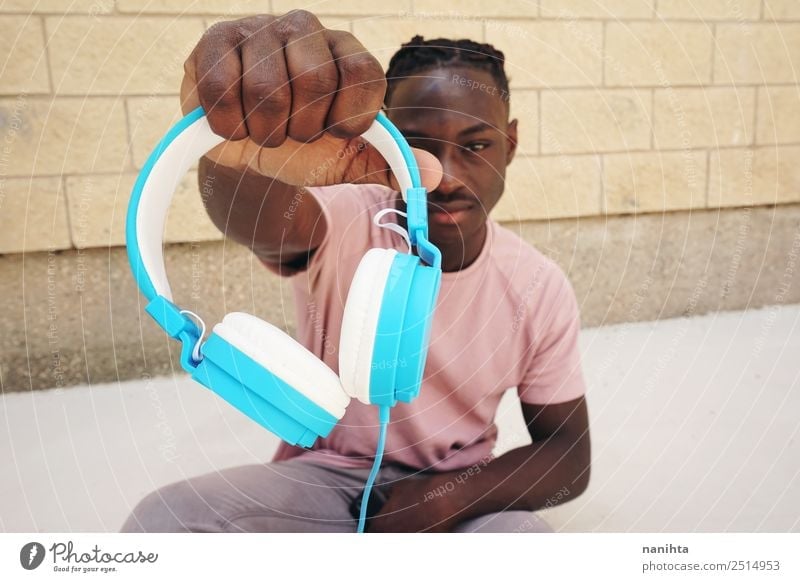 Young man holding headphones Lifestyle Style Design Leisure and hobbies Headset Headphones Technology Entertainment electronics Human being Masculine