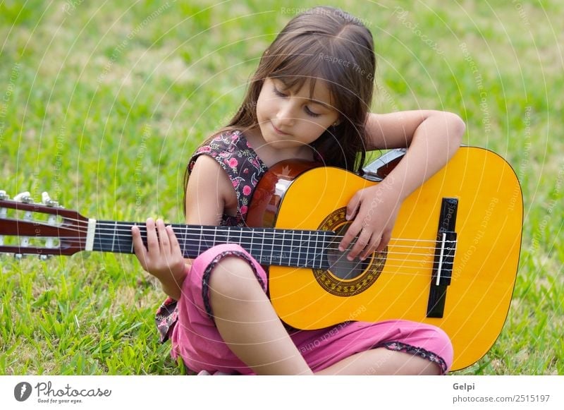 Girl with a guitar Joy Happy Beautiful Playing Music Child Human being Infancy Hand Fingers Guitar Musical notes Grass Sit Happiness Small Cute Green Pink