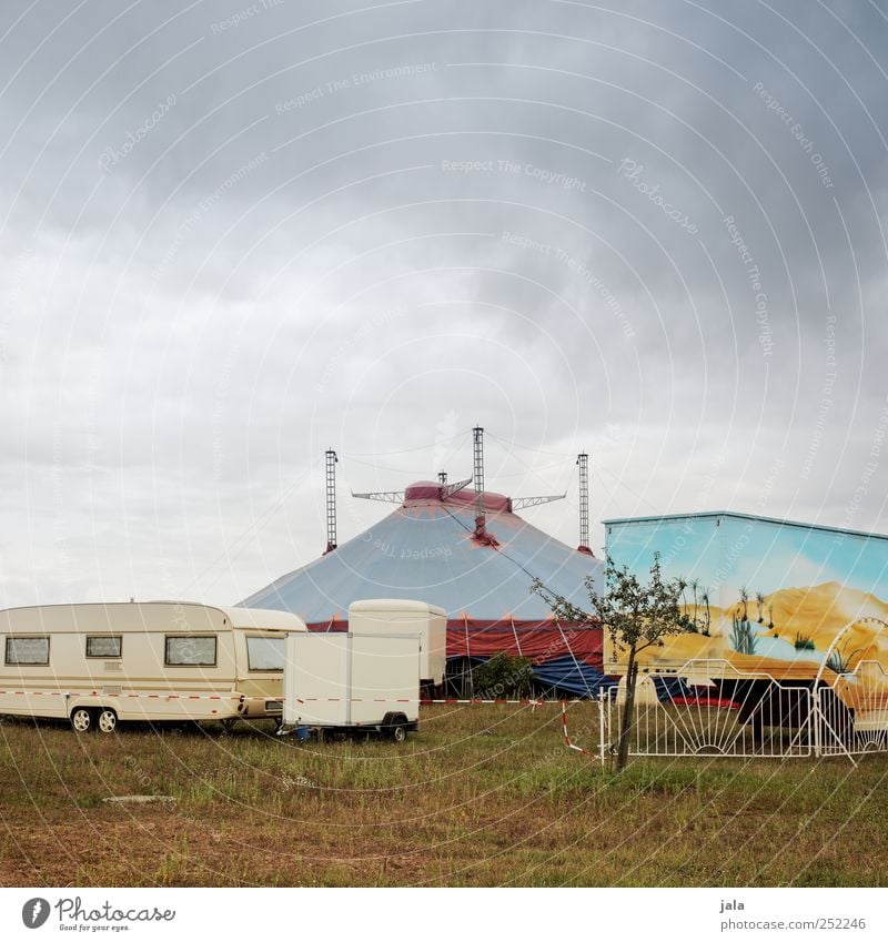 circus Sky Clouds Plant Tree Grass Manmade structures Truck Caravan Trailer Gloomy Tent Circus Circus tent Circus trailer Colour photo Exterior shot Deserted