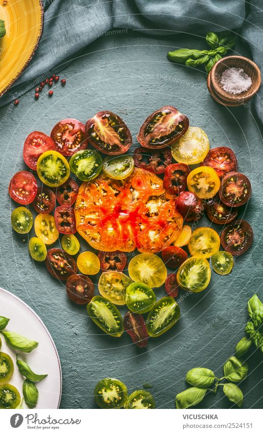 Heart made with colorful halved tomatoes , top view heart maggot food ingredients kitchenmtable above cooking salad healthy