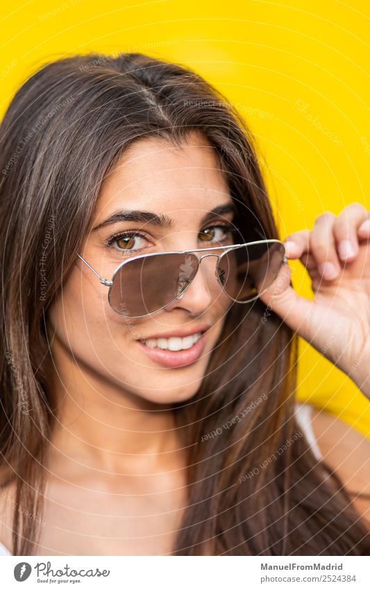 attractive young woman with sunglasses against yellow background Style Joy Happy Beautiful Summer Human being Woman Adults Fashion Sunglasses Smiling Stand