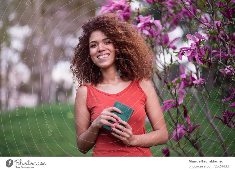 cheerful afro woman holding a book Lifestyle Happy Beautiful Leisure and hobbies Reading Summer Garden School Study Camera Human being Woman Adults Book Nature