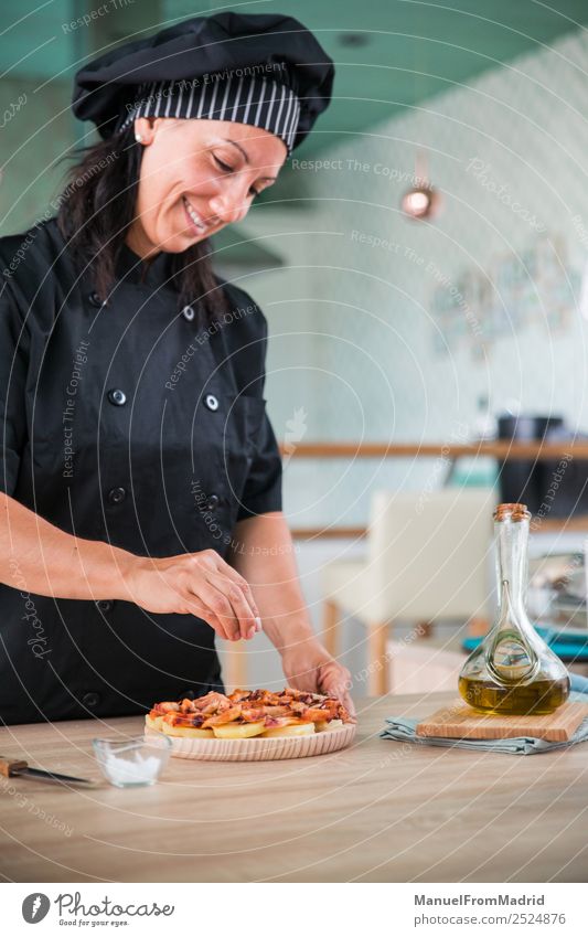 woman chef seasoning a dish Herbs and spices Nutrition Plate Happy Table Kitchen Human being Woman Adults Hand Hat Wood Smiling Modern cook adding salt Octopus