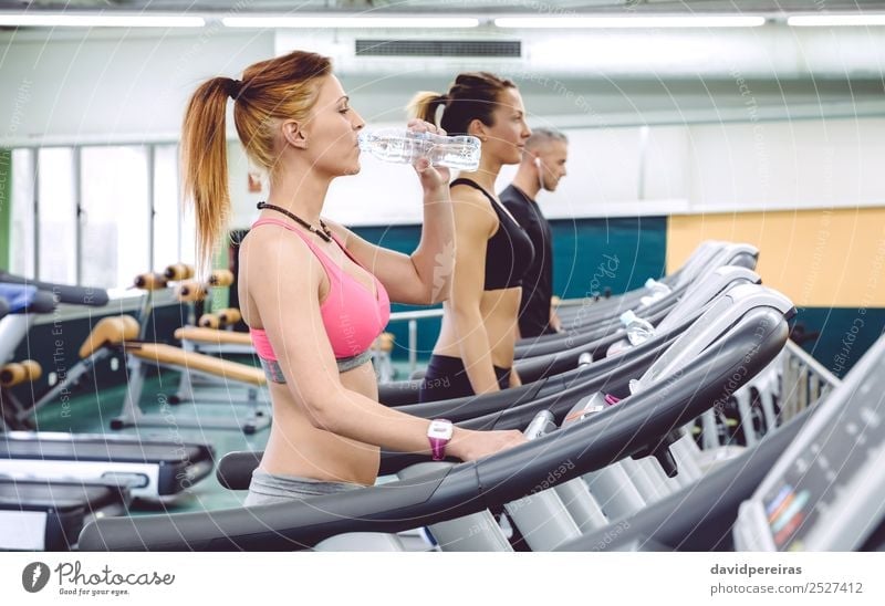 Woman drinking water while training on treadmill Drinking Bottle Lifestyle Beautiful Leisure and hobbies Music Sports Jogging Human being Adults Man Fitness