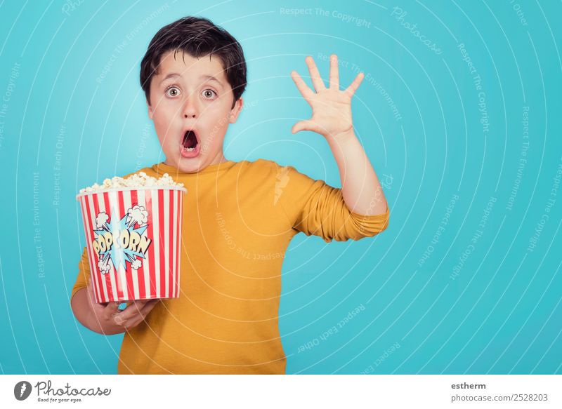 surprised child with popcorn on blue background Food Eating Fasting Lifestyle Joy Leisure and hobbies Entertainment Human being Masculine Child Toddler Infancy