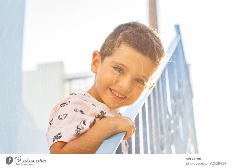 Little boy leaning on a railing in a white and blue village Lifestyle Joy Happy Beautiful Face Vacation & Travel Tourism Summer Summer vacation Island Child