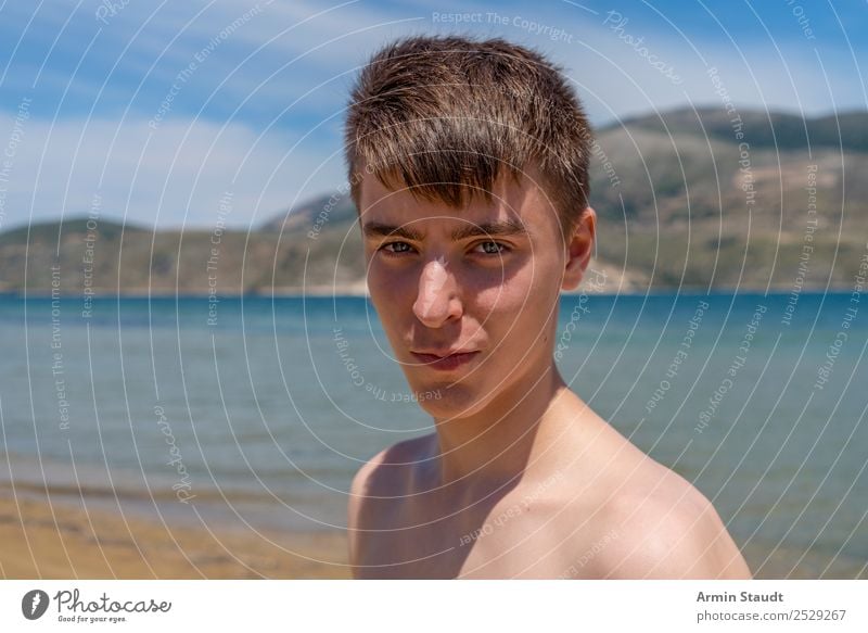 portrait of a young man at the beach holiday sunbathe vacation smiling nature ocean sea summer journey trip travel teenager looking boy male beautiful casual