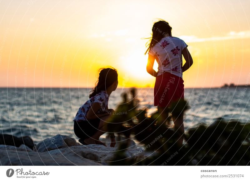 Two girls on the breakeater at sunset Lifestyle Joy Happy Beautiful Relaxation Vacation & Travel Camping Summer Sun Beach Ocean Child Boy (child)