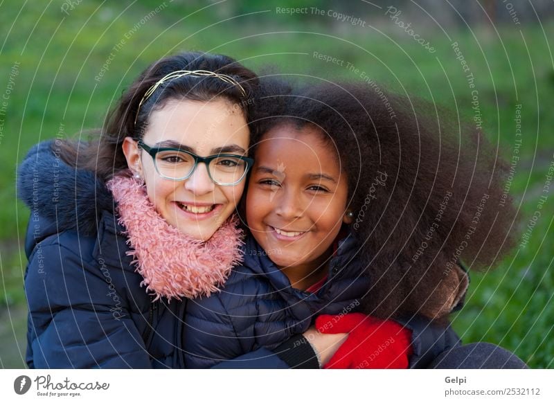 Two happy girls in the park with coats Joy Happy Beautiful Face Winter Child Human being Family & Relations Friendship Infancy Grass Park Coat Scarf Gloves Afro