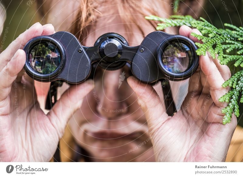 a woman looks through binoculars Human being Feminine Woman Adults 1 Spring Summer Beautiful weather Red-haired Binoculars Observe Curiosity Jealousy Envy