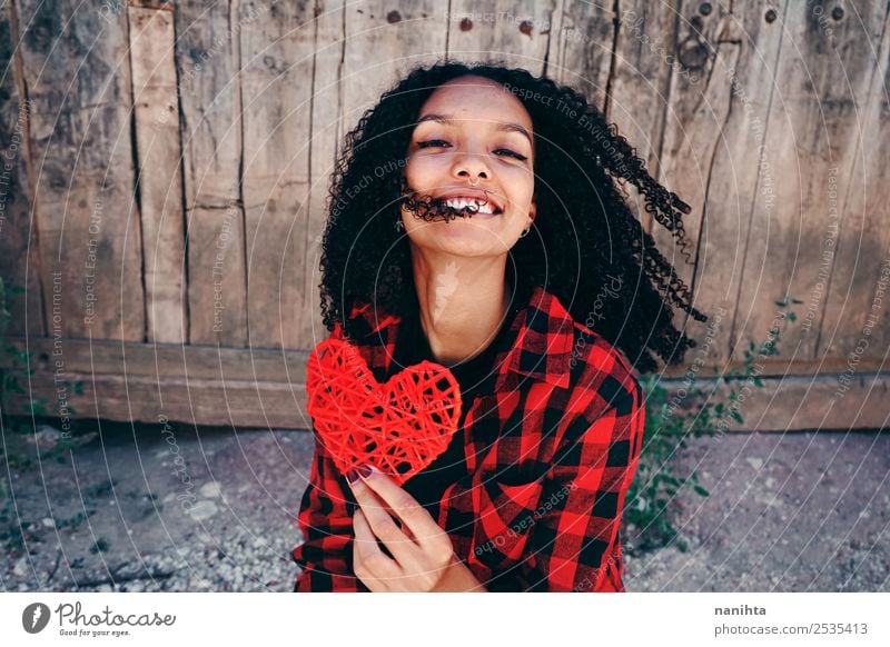 Happy young woman holding a red heart Lifestyle Style Design Joy Hair and hairstyles Healthy Wellness Harmonious Human being Feminine Young woman