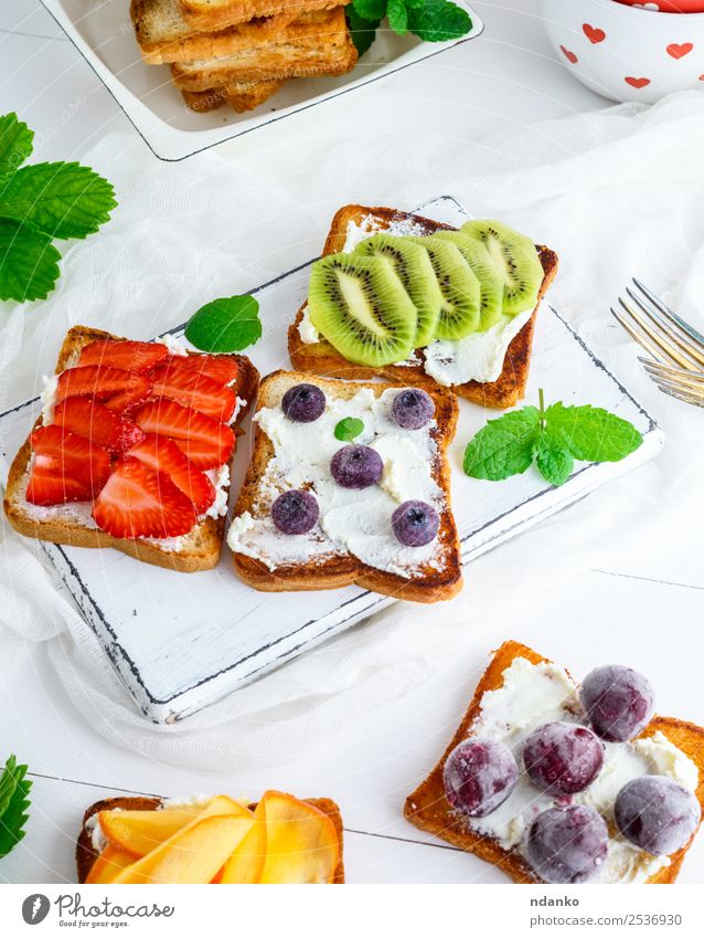 French toasts with soft cheese Cheese Fruit Bread Breakfast Lunch Wood Above Soft Green Red White Strawberry kiwi Blueberry Dairy persimmon Cherry Sandwich