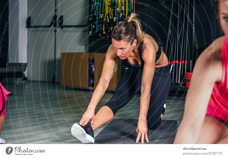 Woman stretching legs in a fitness class Lifestyle Happy Beautiful Body Leisure and hobbies Sports School Human being Adults Arm Group Braids Fitness Authentic
