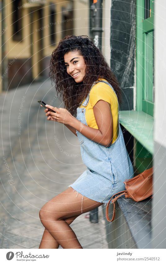 African woman texting with her smart phone. Lifestyle Style Happy Beautiful Hair and hairstyles Telephone PDA Technology Human being Feminine Girl Young woman
