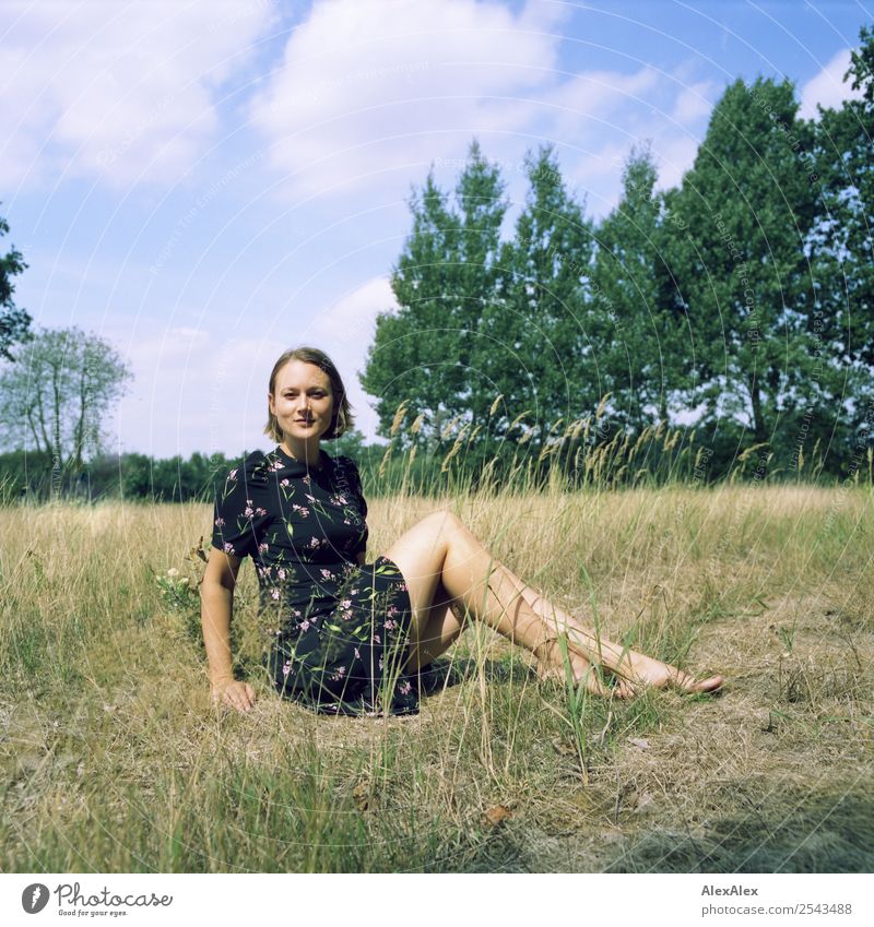 analogue medium format portrait of a young woman sitting barefoot in a summer dress on a field in the heath Joy already Wellness Harmonious Well-being