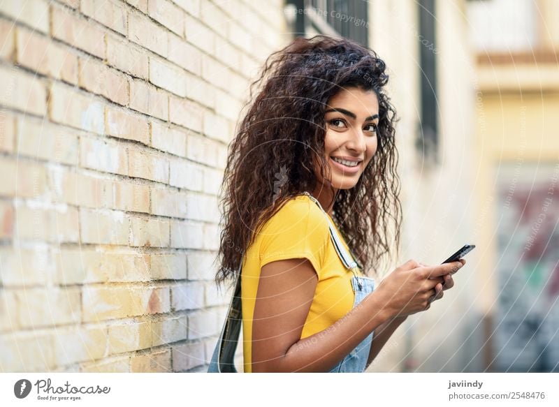 Young Arab woman texting with her smart phone Lifestyle Style Happy Beautiful Hair and hairstyles Telephone PDA Technology Human being Feminine Girl Young woman