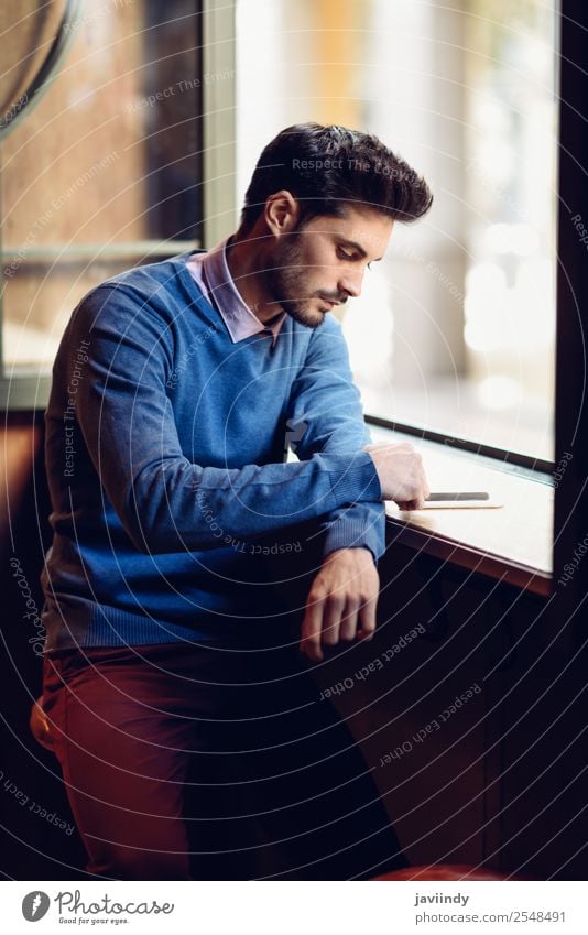 Guy with blue sweater looking at his smartphone in a bar Lifestyle Style Beautiful Hair and hairstyles Telephone PDA Human being Masculine Young man