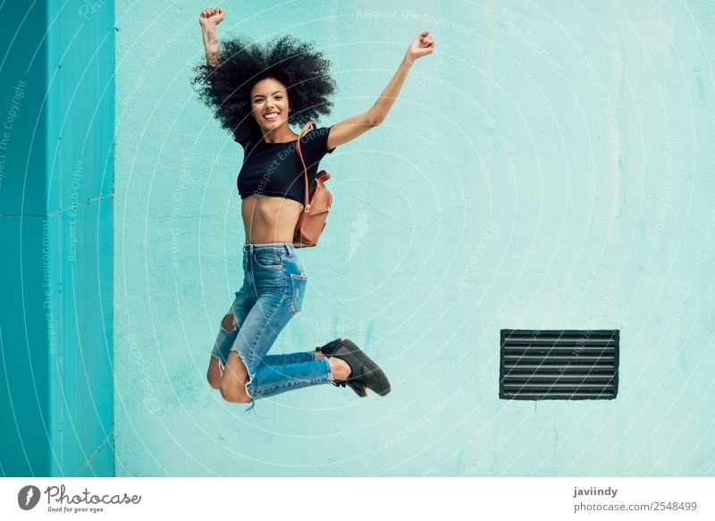Young mixed woman with afro hair jumping outdoors Lifestyle Style Happy Hair and hairstyles Face Human being Feminine Young woman Youth (Young adults) Woman