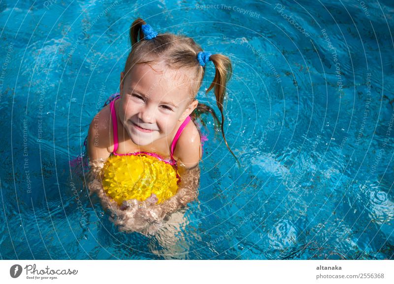 happy little girl playing in the pool with ball Lifestyle Joy Happy Face Relaxation Swimming pool Leisure and hobbies Playing Vacation & Travel Summer Sun