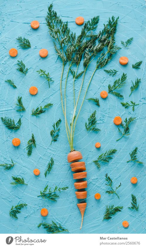 Carrot cut into slices on blue background. Flat lay. Vegetable Nutrition Vegetarian diet Happy Beautiful Healthy Life Summer Decoration Art Nature Plant Leaf
