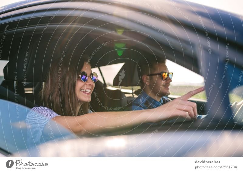 Young man driving a car with his girlfriend Lifestyle Joy Happy Beautiful Leisure and hobbies Vacation & Travel Trip Adventure Freedom Human being Woman Adults