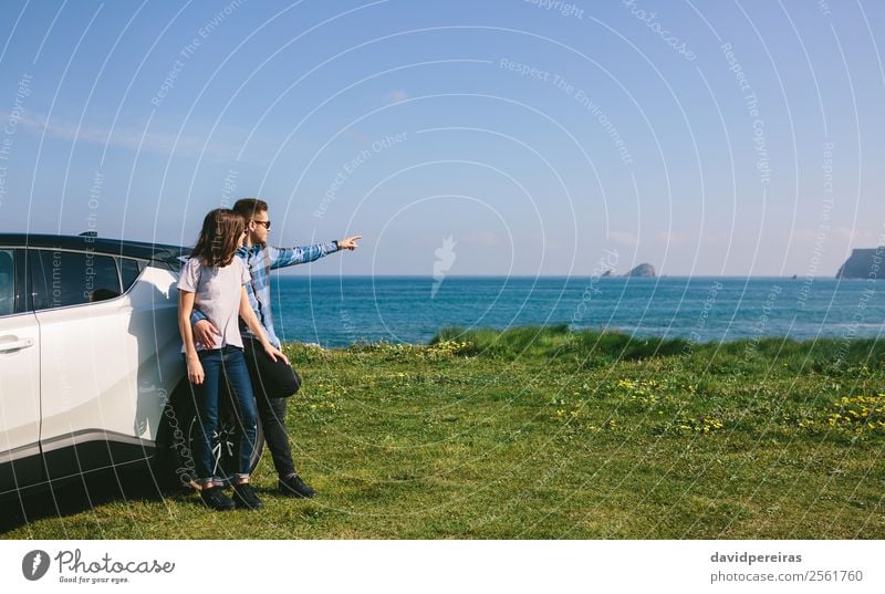 Couple with car watching landscape Lifestyle Vacation & Travel Trip Adventure Ocean Human being Woman Adults Man Nature Landscape Grass Meadow Rock Coast Car