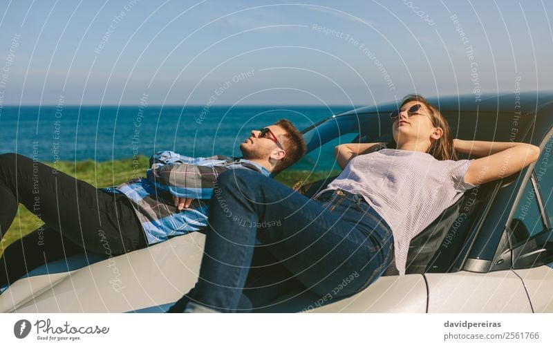 Young couple lying on the windshield Lifestyle Style Relaxation Calm Vacation & Travel Freedom Sunbathing Ocean Human being Woman Adults Man Couple Nature