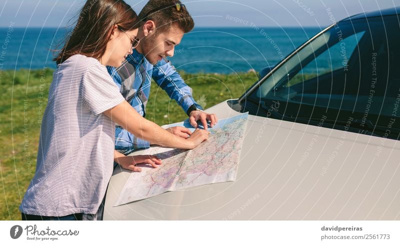 Couple looking at a map leaning on the car Beautiful Vacation & Travel Trip Adventure Ocean Human being Woman Adults Man Grass Meadow Coast Vehicle Car