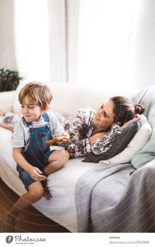 mother and son spending morningtime in living room Eating Breakfast Lunch Lifestyle Happy Living room Boy (child) Woman Adults Parents Mother Family & Relations