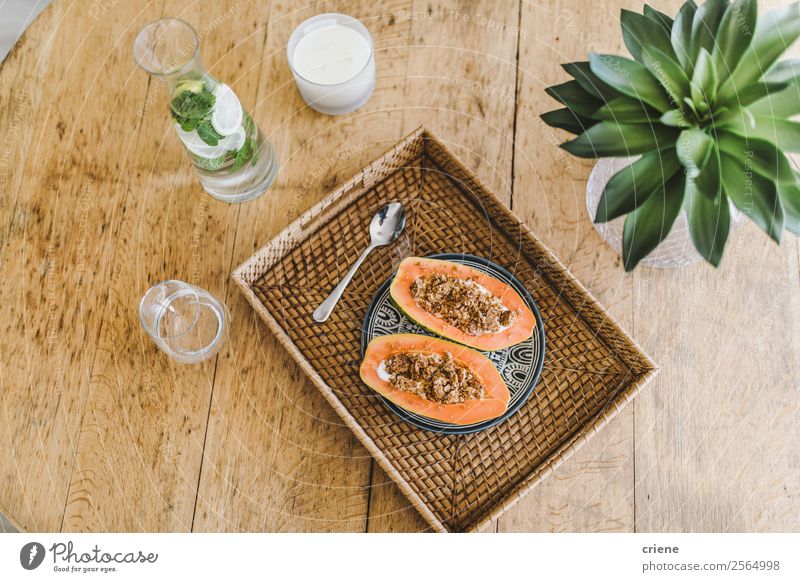 closup of preparing papaya with cereals in kitchen Yoghurt Fruit Dessert Vegetarian diet Diet Exotic Summer Table Nature Plant Leaf Wood Fresh Delicious Natural