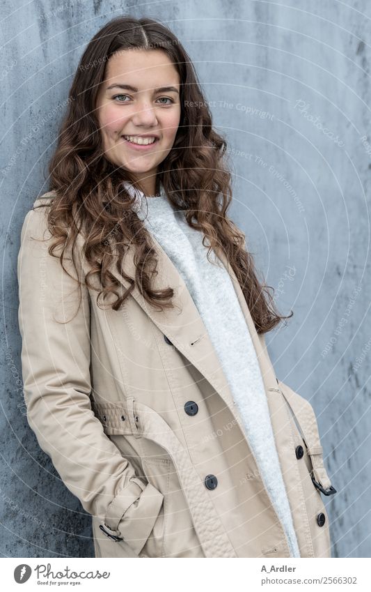 Young woman in a coat Human being Places Wall (barrier) Wall (building) Fashion Clothing Coat Brunette Long-haired Curl Smiling Cool (slang) Friendliness