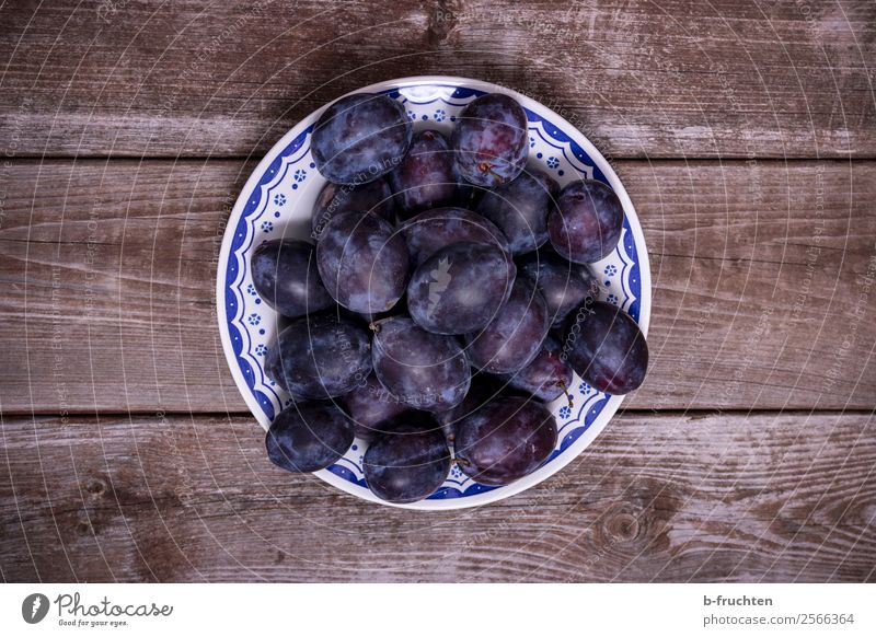 Plums on a plate Food Fruit Organic produce Vegetarian diet Plate Bowl Agriculture Forestry Fresh Healthy Blue Round Harvest Garden Wooden board Wooden table
