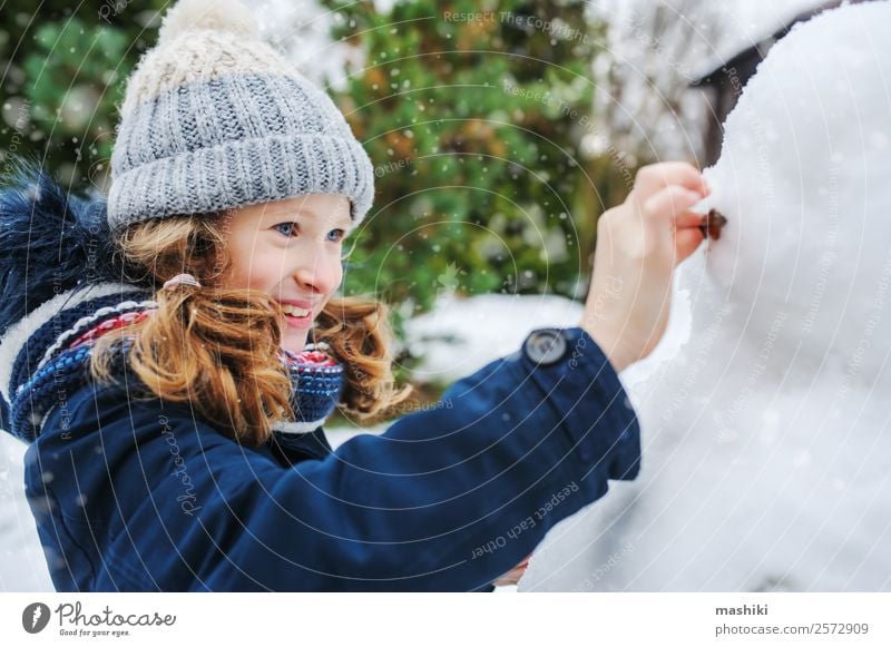 happy kid girl making snow man on Christmas Joy Leisure and hobbies Playing Vacation & Travel Winter Snow Garden Child Nature Weather Park Clothing Make Snowman