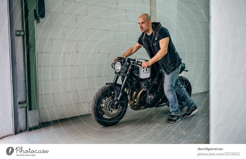Man with custom motorbike leaving the garage Lifestyle Style Vacation & Travel Trip Engines Human being Adults Street Motorcycle Jeans Bald or shaved head Stand