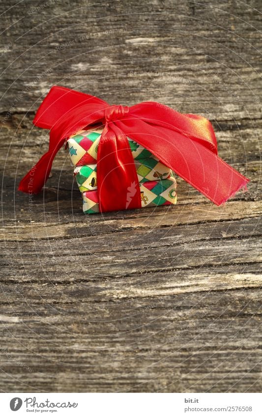 colourful christmas parcels packed with christmas paper with red bow, on rustic wood. Christmas presents, lie nicely decorated with ribbon on wooden table. Many Christmas parcels wrapped with wrapping paper with Christmas motif. Concept gifts Advent.