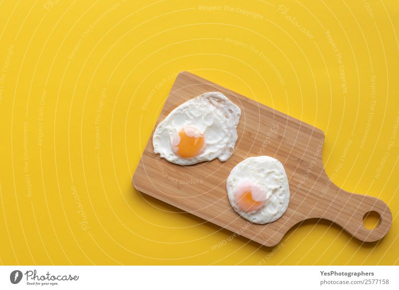 Friedd eggs on a cutting board Food Nutrition Breakfast Lunch Diet Plate Fresh Healthy Bright Delicious Sweet Warmth Yellow above view Cooking Copy Space