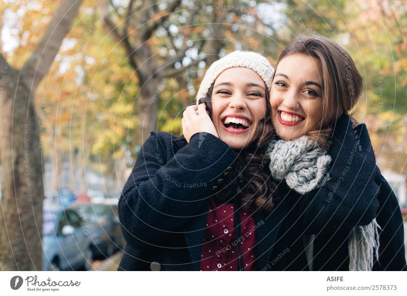 Laughing best friends hugging outdoors in autumn Lifestyle Joy Happy Beautiful Winter Woman Adults Friendship Youth (Young adults) Autumn Park Fashion Scarf
