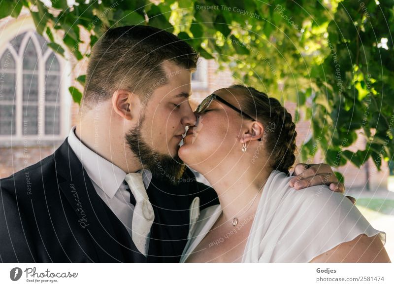 Wedding couple kisses in front of the church Masculine Feminine Young woman Youth (Young adults) Young man 2 Human being 18 - 30 years Adults 30 - 45 years