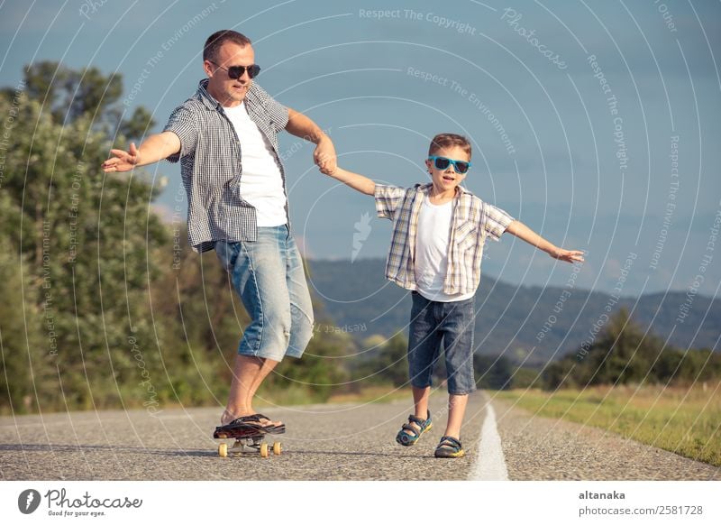 Father and son playing on the road at the day time. People having fun outdoors. Concept of friendly family. Lifestyle Joy Happy Leisure and hobbies Playing