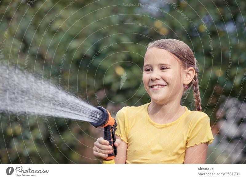 Happy little girl pouring water from a hose. Joy Leisure and hobbies Playing Vacation & Travel Freedom Camping Summer House (Residential Structure) Garden Child