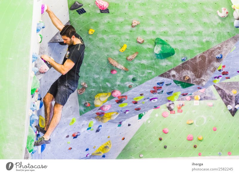 A Man practicing rock climbing on artificial wall indoors Lifestyle Joy Leisure and hobbies Sports Climbing Mountaineering Young man Youth (Young adults) Adults