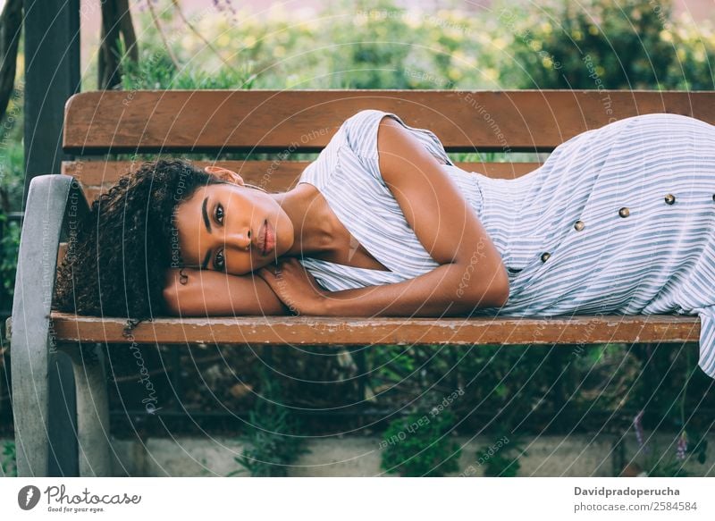 Beautiful young black woman laying down on a chair in a park Woman Beauty Photography Close-up Portrait photograph multiethnic Black African