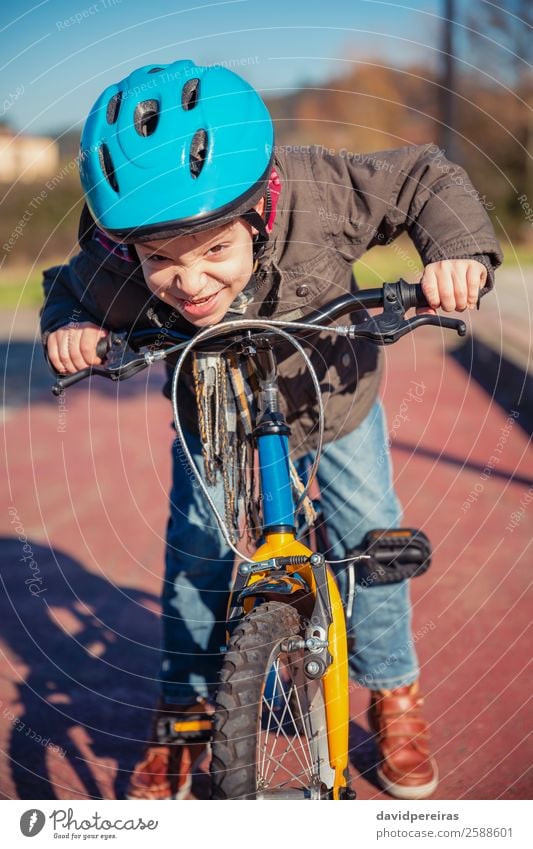Naughty boy with defiant gesture over his bike Lifestyle Happy Face Leisure and hobbies Playing Sun Winter Sports Cycling Child Human being Boy (child) Street